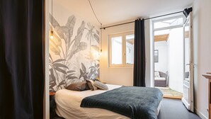 Une chambre à coucher avec un lit, une fenêtre et une vue sur un espace extérieur.