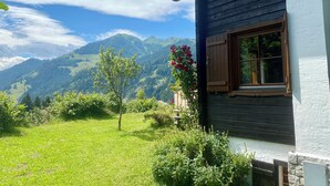 Una casa con ventana y vistas a las montañas.