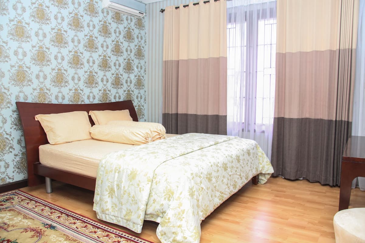 Une chambre à coucher avec un lit, des rideaux et un tapis à motifs.