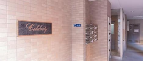Un couloir avec une pancarte « Celebrity » sur le mur, une pancarte bleue indiquant les numéros de chambre « 3 à 6 », et un escalier.