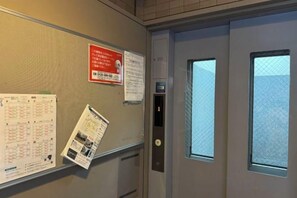 Una puerta con ventanal, un tablón de anuncios y un cierre con teclado.