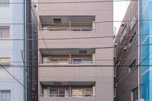 A multi-story building with balconies and a visible power line. - Sumida Midori APT (Tokyo)