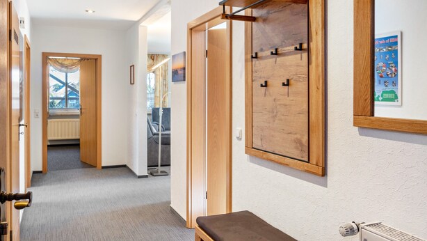 A hallway with wooden doors, a bench, and a radiator. - Apartment 'Kirschner's 2' with Shared Terrace and Wi-Fi (Horumersiel-Schillig)