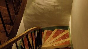 En spiraltrappe med trægelændere og en murstensvæg.