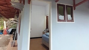 A covered porch with a wooden ceiling, a bed, and a small potted plant. - Pondok Indah At Teluk Asmara Beach (Sitiardjo)