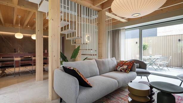 A modern interior with a grey sofa, round side tables, and a dining area with a table and chairs. - 3 bedroom house with Jacuzzi (Hotton)