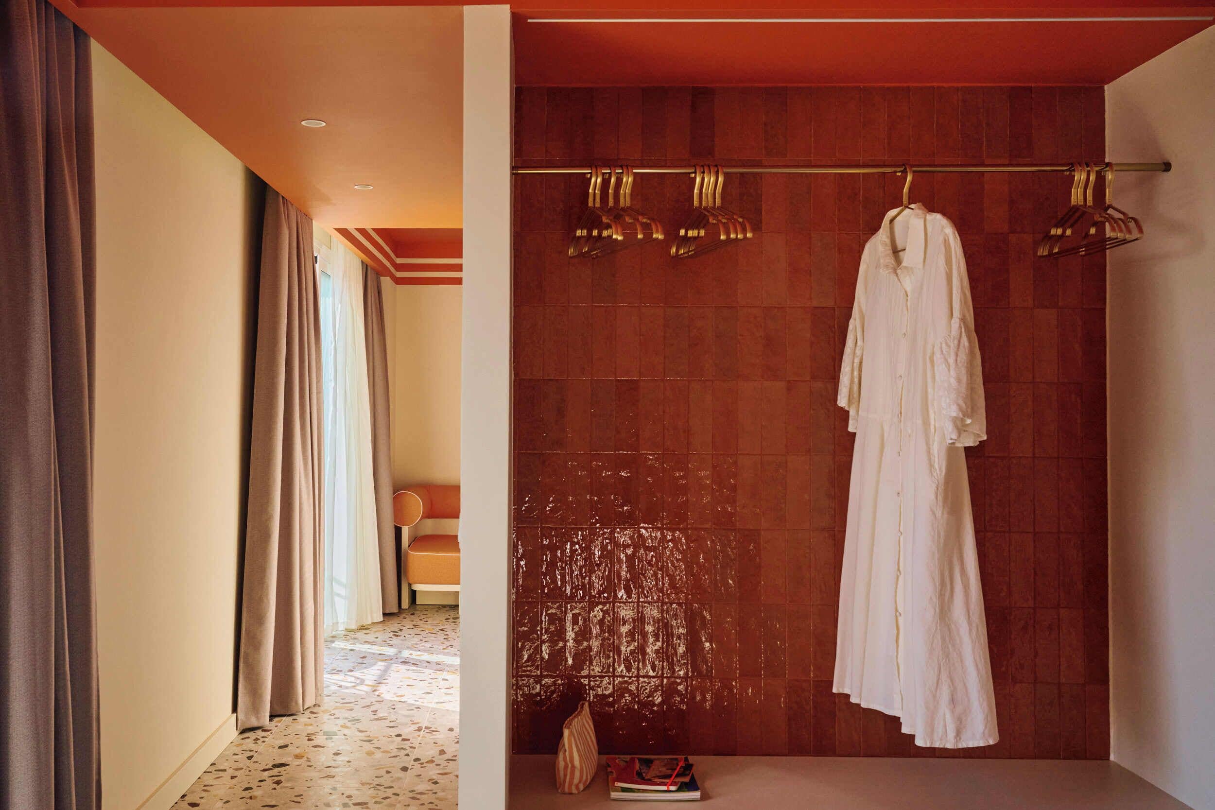A hotel bathroom with a wooden wall, a towel rack with a white towel, and a shower area.