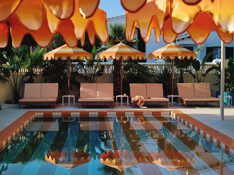 A swimming pool with lounge chairs and umbrellas.