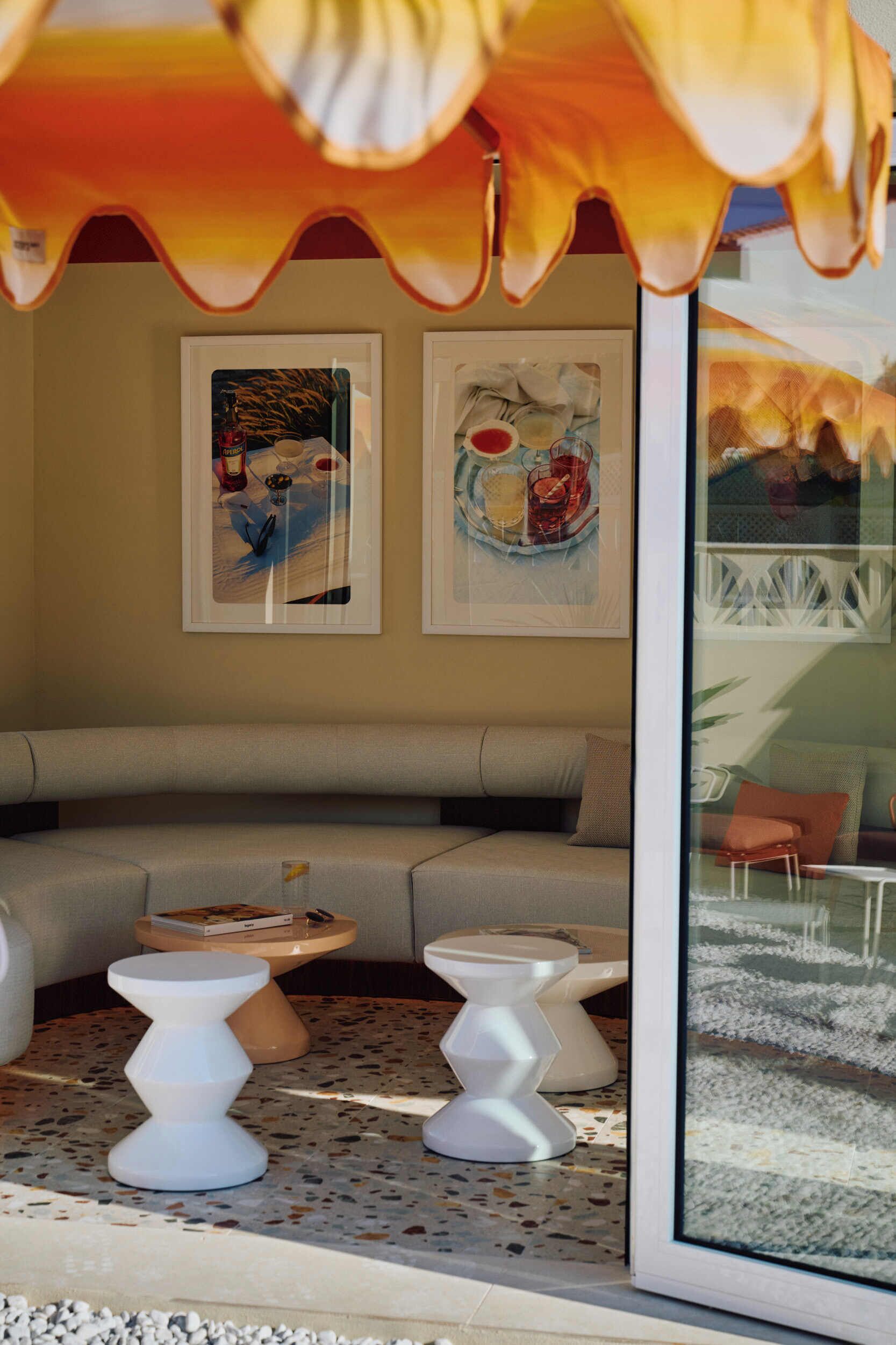 A modern living room with a sofa, two white side tables, and artwork on the wall.