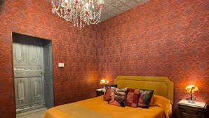 Une chambre à coucher avec un grand lit, un plafond décoré et des murs à motifs.