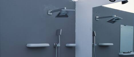 A modern bathroom with a shower, a sink, and a mirror.