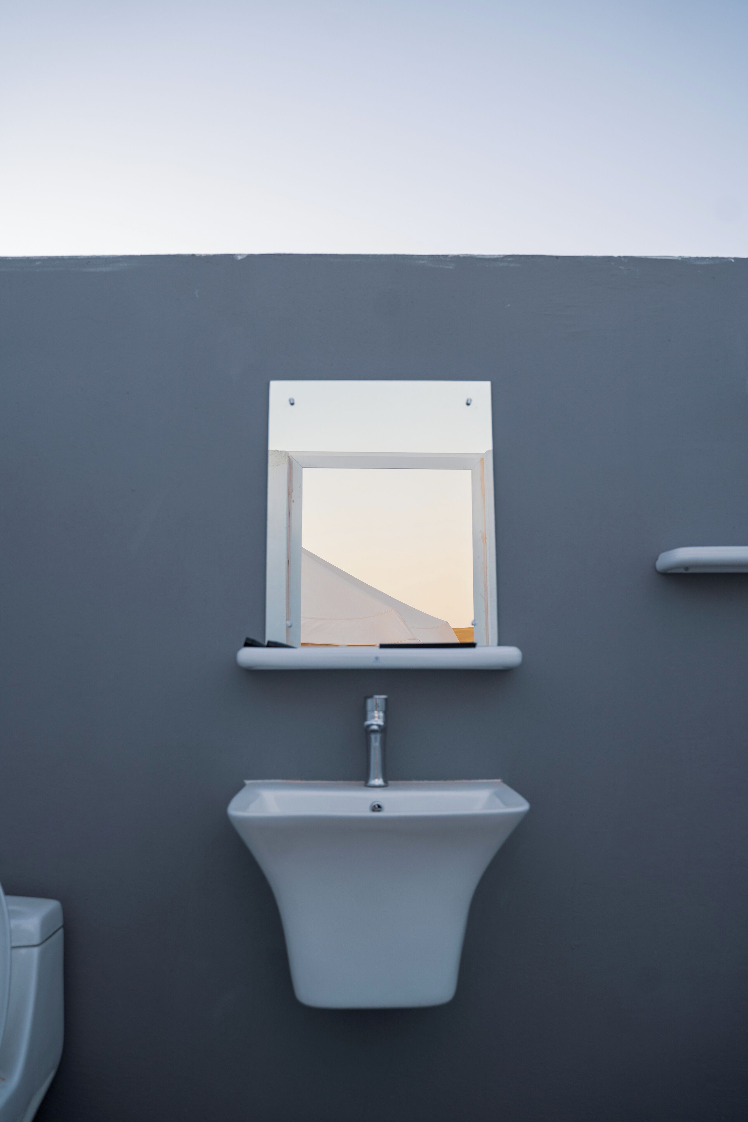 A bathroom with a white toilet, a white sink, and a window above the sink.
