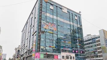 A multi-story commercial building with various signs and advertisements on its facade.