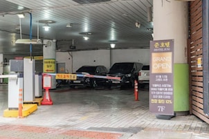 Entrada a un estacionamiento con un cartel anunciando su inauguración.
