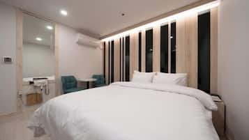 Quarto moderno com uma cama grande, uma pequena escrivaninha e uma cadeira.