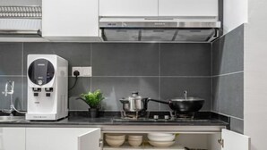 A modern kitchen with a built-in water dispenser, a stove, and a cabinet with dishes.