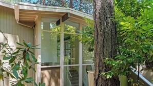 Un petit bâtiment d’un seul étage, doté d’une porte et de fenêtres en verre, entouré d’arbres.