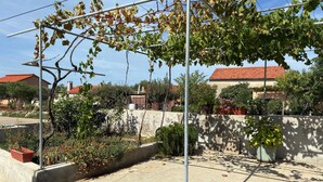 A residential area with a garden, a metal pergola, and houses with red roofs. - Gorgeous apartment in Sukosan with WiFi (Sukosan)