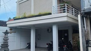 A multi-story building with a covered parking area. - Koura Jimbaran (Bali)