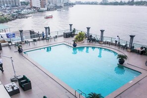 Piscina sul tetto con vista sul fiume e sulle barche.