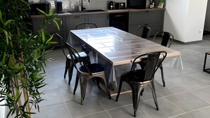 Une cuisine moderne avec une table à manger, des chaises et une plante en pot.
