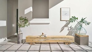 A modern interior with a wooden bench, potted plants, and a framed picture on the wall. - Express by M Village Tran Quoc Thao, a brand of Modern Village Lifestyle (Ho Chi Minh City)