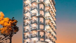 A high-rise hotel with multiple balconies, a prominent entrance, and a modern architectural design. - RHM Luxury Hotel and Suite  (Da Nang)