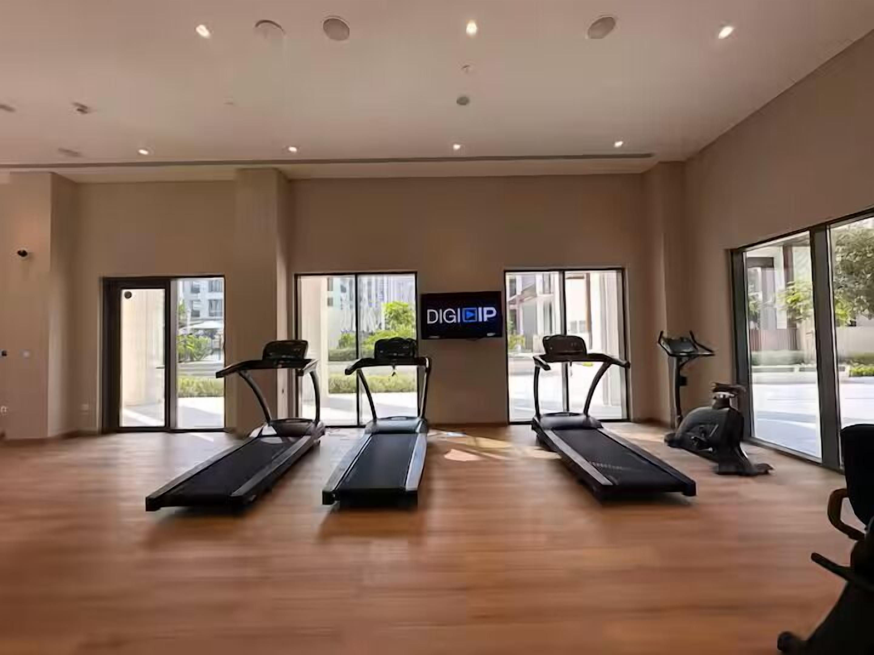Una palestra con tapis roulant, una cyclette e uno schermo televisivo che mostra 'DIGIIP'.
