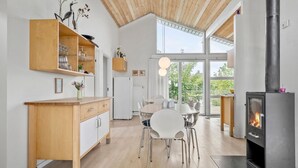 Eine moderne Küche mit einer zentralen Kochinsel, Holzschränken und einem eingebauten Holzofen.