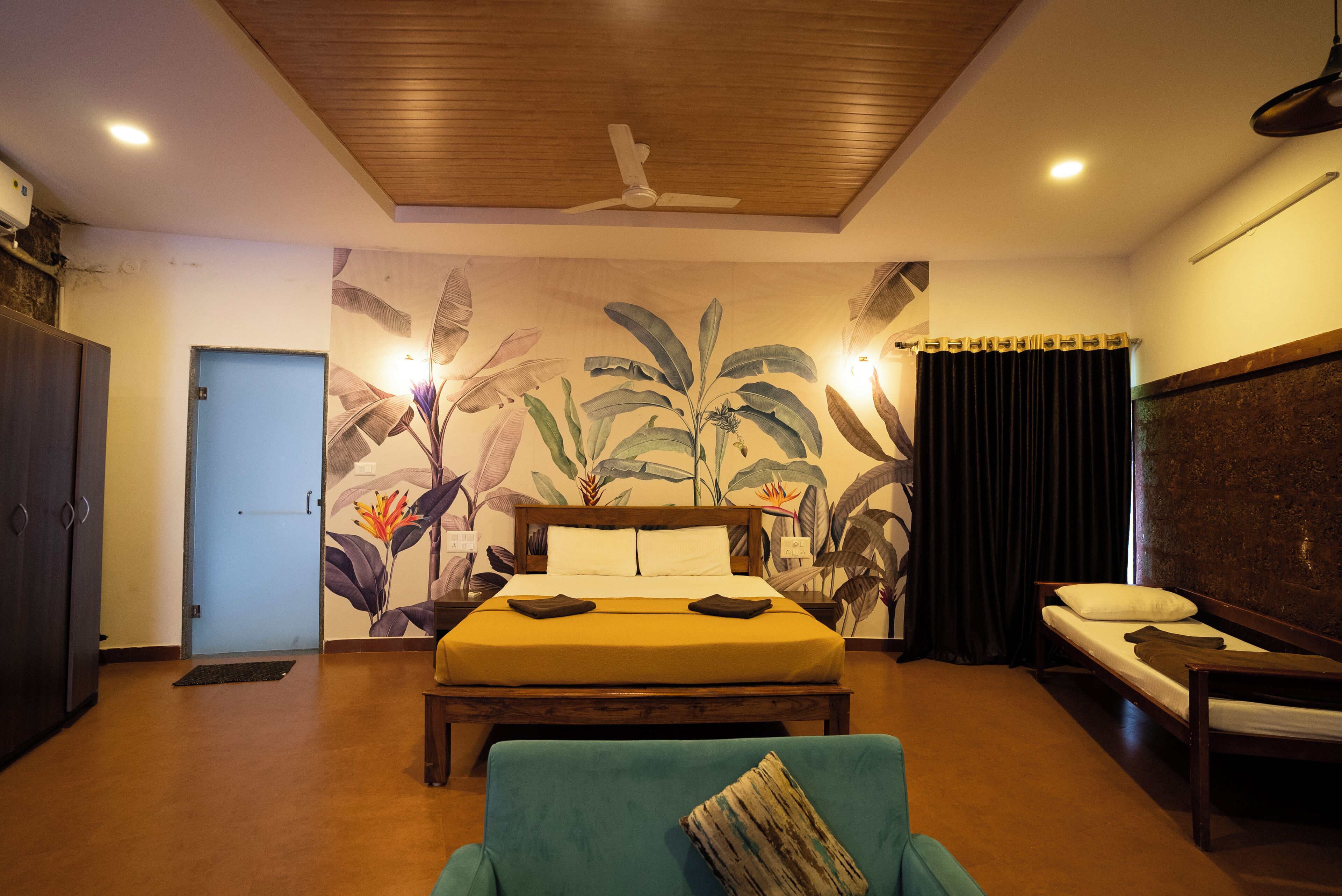Ein Schlafzimmer mit Bett, Sofa, Deckenventilator und Wandbild.