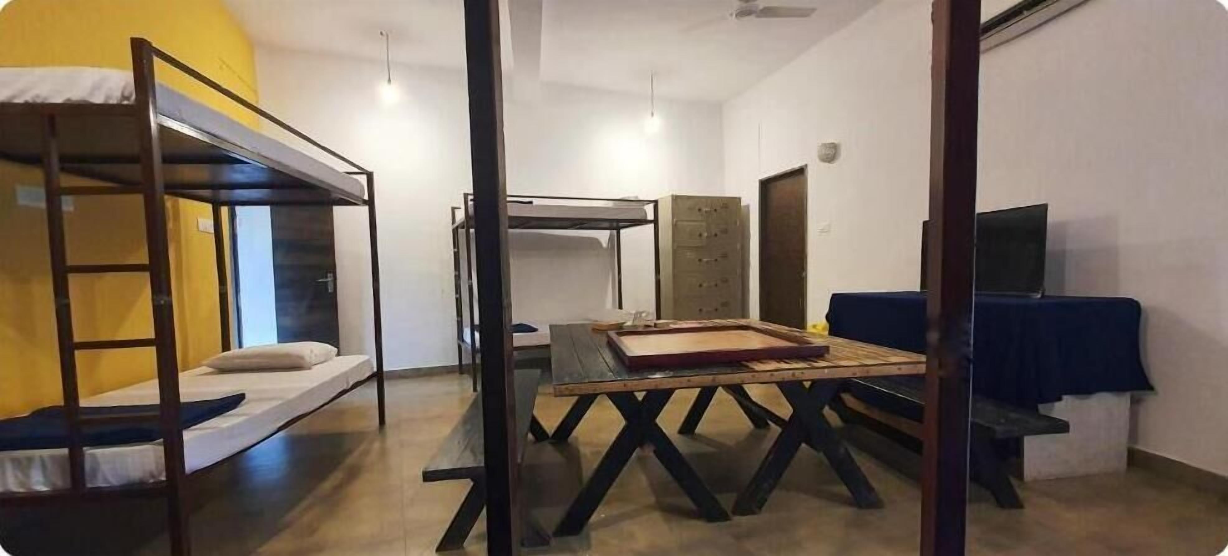 Un dormitorio con literas, una mesa de madera y un escritorio con silla.
