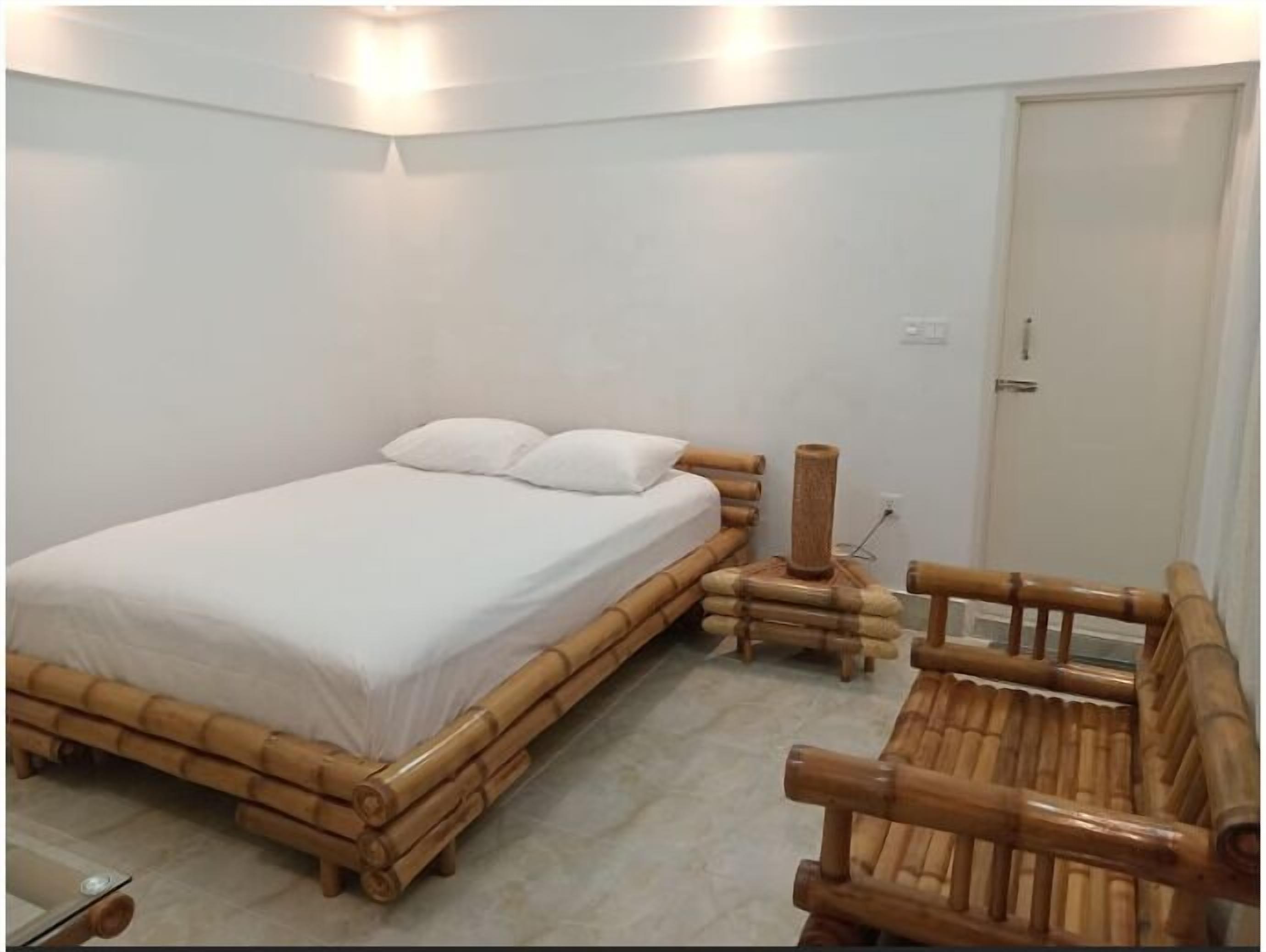 Ein Zimmer mit einem Bett, einem Holzstuhl und einem kleinen Tisch.