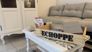 A white table with a wooden crate labeled 'ECHOPPE' containing a book, a mug, and a bag of cookies.
