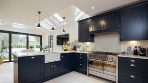 A modern kitchen with dark cabinetry, a central island, and a large stove.