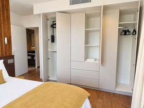 A bedroom with a bed, a wardrobe, and a bathroom.