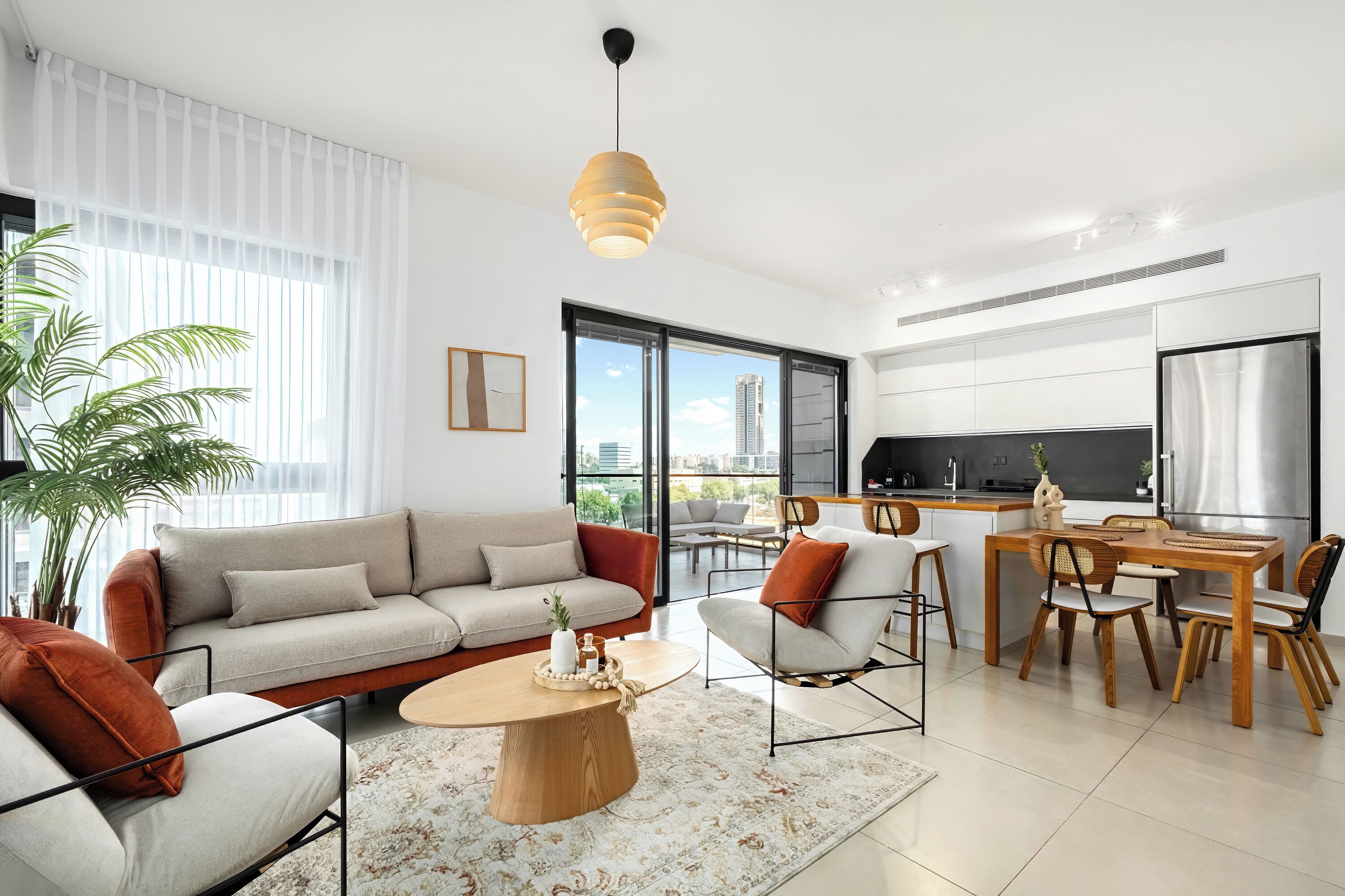 A modern living room with a sofa, coffee table, and dining area.