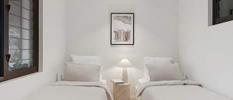A hotel room with two beds, a nightstand with a lamp, and a framed picture on the wall.