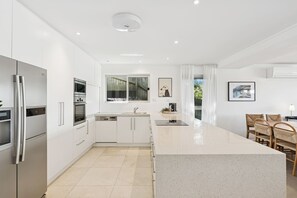 Una cocina moderna con armarios blancos, electrodomésticos de acero inoxidable y una isla grande.