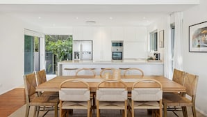 A modern kitchen with white cabinets, stainless steel appliances, and a central island.
