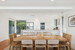 Una cocina moderna con armarios blancos, electrodomésticos de acero inoxidable y una isla central.