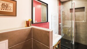 A modern bathroom with a shower, a sink, and a mirror.