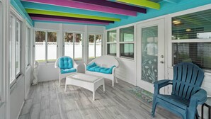 A sunroom with colorful ceiling beams, white furniture, and large windows. - Tranquil & Spacious Heated Pool, Hot Tub, Parking (Englewood)