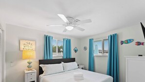 A bedroom with a bed, nightstands, a lamp, a ceiling fan, and a window with curtains. - Tranquil & Spacious Heated Pool, Hot Tub, Parking (Englewood)