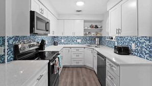 A modern kitchen with white cabinets, a microwave, a toaster, and a blender. - Tranquil & Spacious Heated Pool, Hot Tub, Parking (Englewood)