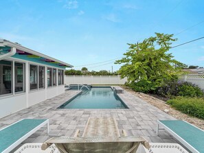 A swimming pool with lounge chairs and a covered area with windows. - Tranquil & Spacious Heated Pool, Hot Tub, Parking (Englewood)