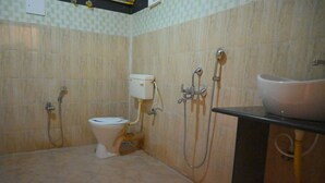A bathroom with a toilet, a sink, and a shower. - Crystal Andaman Resort (Port Blair)
