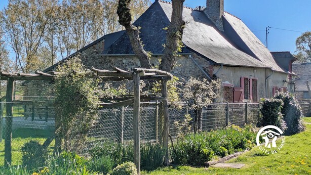 A stone house with a sloped roof and a wooden fence. - Comfortable cottage for 6 with spacious terrace (Saint-Michel-de-la-Roë)