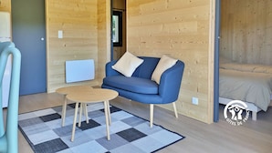 Une pièce chaleureuse avec un canapé bleu, une petite table ronde et un tapis à carreaux.