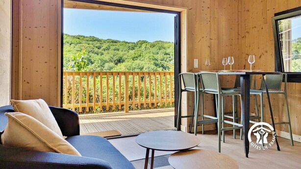 Un intérieur en bois avec un balcon, un canapé, une table et deux chaises.