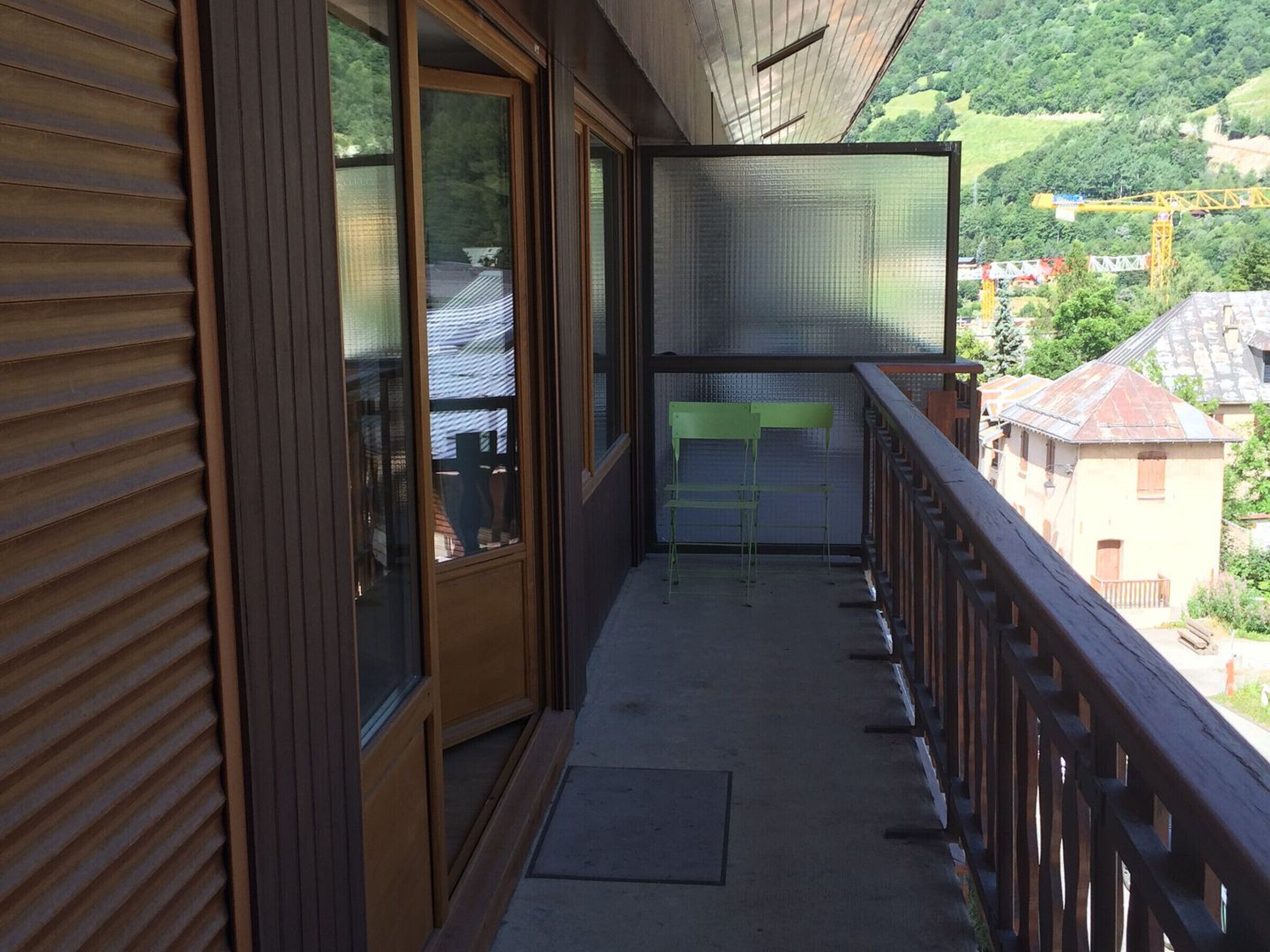 A balcony with a view of a town and hills.